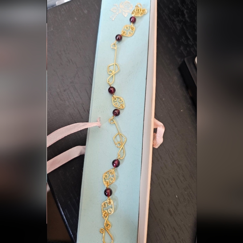 New! Sterling garnet treble cleff bracelet. Bracelet has a gold wash. Not stampe